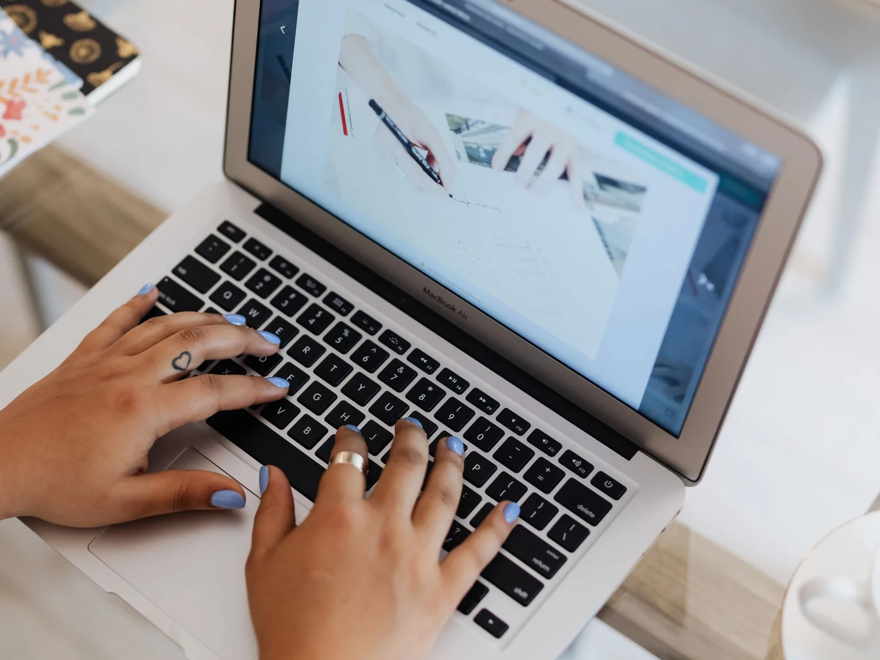Dịch vụ quản trị website 2 Hai bàn tay gõ phím laptop đang mở trang web để cập nhật nội dung.